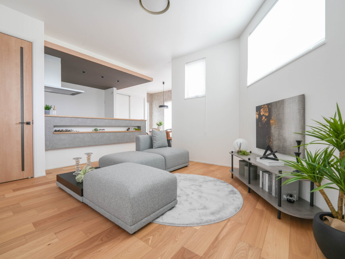 変則的な形のリビングはグレーのソファと腰壁のアクセントクロスで統一感のある空間となっている。