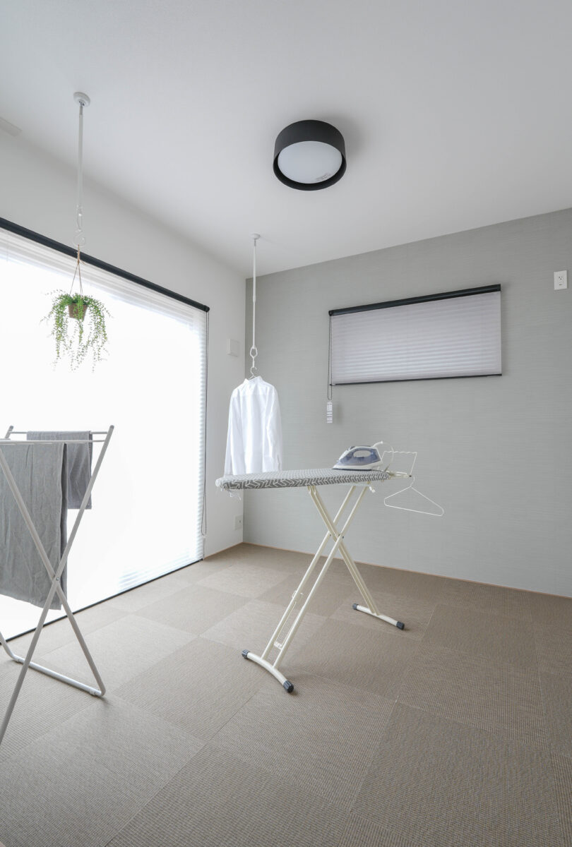 家事室としての利用を考えられたこの空間には中央にアイロン台、傍らにはタオル掛けが置かれており、室内には自然光が入っている。