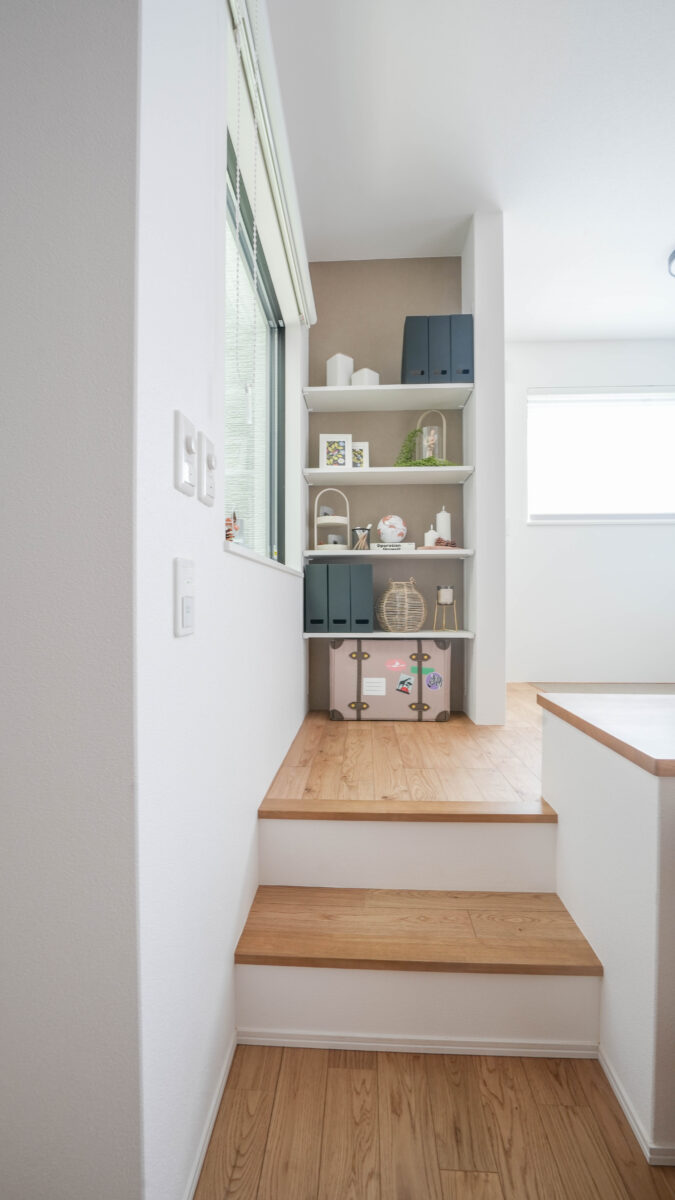 スキップキッズフロアのギャラリーシェルフはシンメトリーの配置を意識しつつ、色付きクロスが映えるよう白い小物が配置され余白を感じる設え。